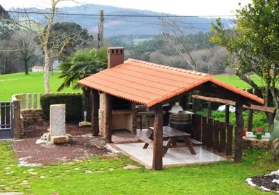 an orange roofed gazebo with a picnic table at Fogar de Insua in Touro