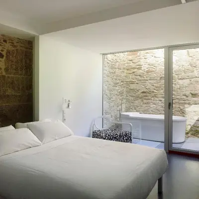 a bedroom with a bed and a bath tub at Moure Hotel in Santiago de Compostela