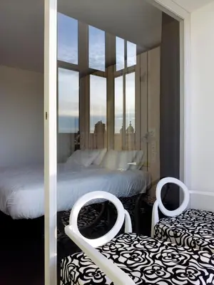 a bedroom with two beds and a large window at Moure Hotel in Santiago de Compostela