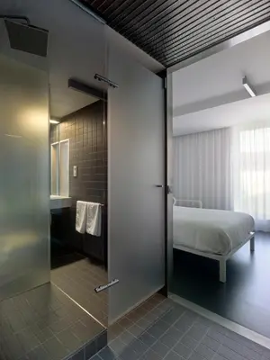 a bedroom with a bed and a sliding glass door at Moure Hotel in Santiago de Compostela