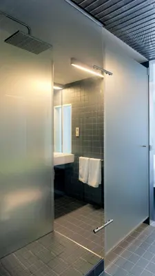 a shower with a glass door in a bathroom at Moure Hotel in Santiago de Compostela