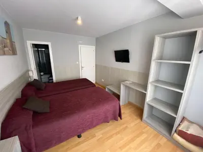 a bedroom with a red bed and a book shelf at dpCristal in Sarria