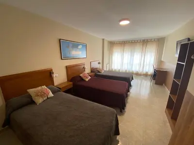 a hotel room with two beds and a couch at dpCristal in Sarria