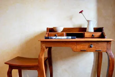 a wooden table with a vase and a flower on it at La Lechería in Val de San Lorenzo