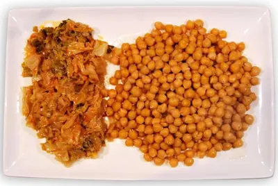 a white plate of food with beans and meat at La Lechería in Val de San Lorenzo