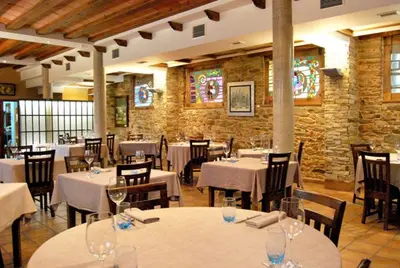 a dining room with tables and chairs with wine glasses at La Lechería in Val de San Lorenzo