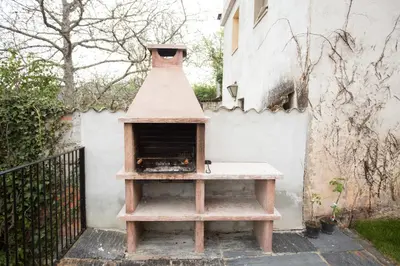a pizza oven sitting on a stand next to a wall at Os Feleitos in Orellán