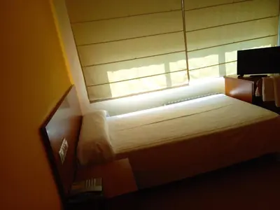 a bedroom with a bed and a window with the sunlight at Pension San Roque in Lugo