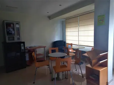 a classroom with tables and chairs and a room with a window at Pension San Roque in Lugo