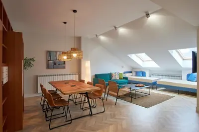 a dining room and living room with a table and chairs at Apartamentos Los Arroyos in Ponferrada
