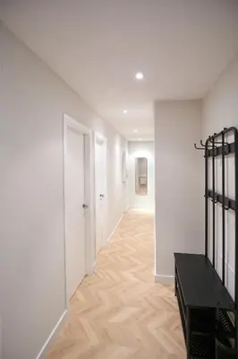 a hallway with white walls and a wooden floor at Apartamentos Los Arroyos in Ponferrada