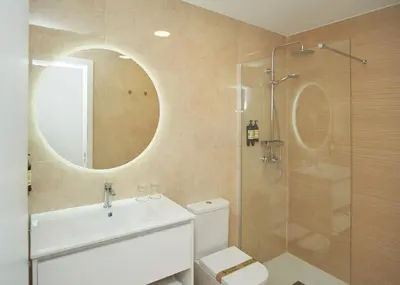 a bathroom with a toilet and a sink and a mirror at Apartamentos Los Arroyos in Ponferrada