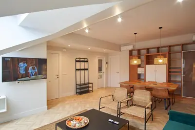 a kitchen and living room with a table and chairs at Apartamentos Los Arroyos in Ponferrada