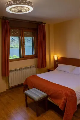 a bedroom with a large bed and a window at Hotel Don Pepe Lago de Sanabria in Ribadelago