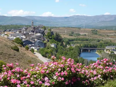 a town on a hill with pink flowers at Hostal Carlos V in Puebla de Sanabria