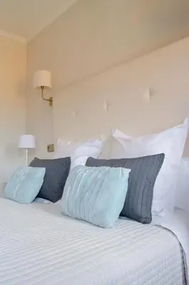 a bed with blue and white pillows on it at Hostal Carlos V in Puebla de Sanabria