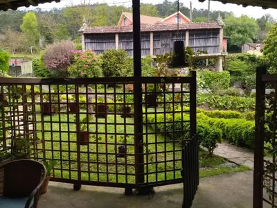 a garden gate with a garden in the background at Casa Dos Cregos in Bascuas