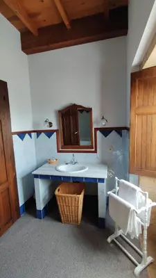 a bathroom with a sink and a mirror and a chair at Casa Dos Cregos in Bascuas