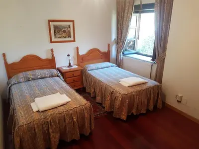 a bedroom with two beds and a window at Casa da Ponte in Ferreira