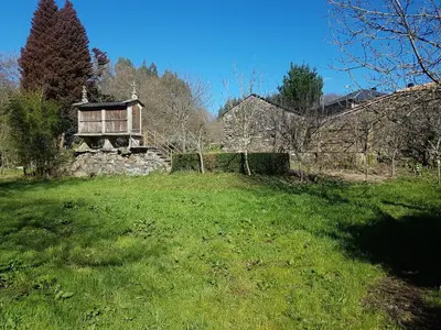 a grassy field with a building in the background at Casa da Ponte in Ferreira