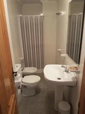 a white bathroom with a toilet and a sink at Casa da Ponte in Ferreira