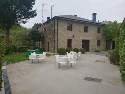a patio with white tables and chairs in front of a building at Casa da Ponte in Ferreira