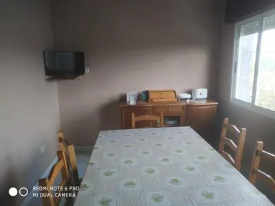 a dining room with a table and a television at Secondary home in Lobios