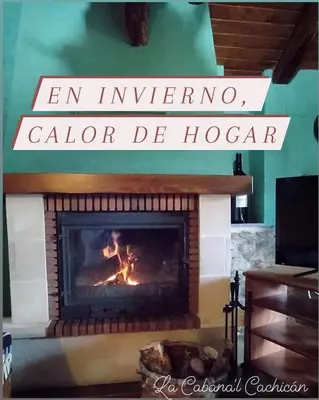 a fireplace in a room with a fire in it at La Cabana´l Cachican in Cangas del Narcea