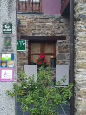 a door to a building with flowers on it at La Cabana´l Cachican in Cangas del Narcea