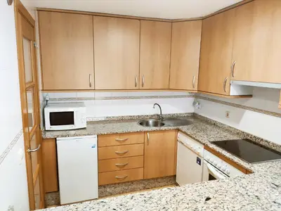 an empty kitchen with a sink and a microwave at Casa Riquiña in Santiago de Compostela