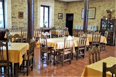a dining room with tables and chairs with yellow tablecloths at Hotel Rural Molino del Arriero in Luyego de Somoza
