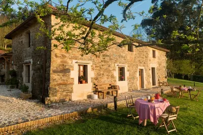 a stone house with a table in front of it at A Casa da Torre Branca in Santiago de Compostela