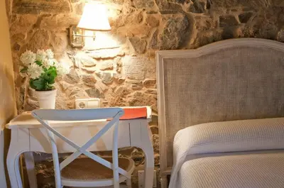 a bedroom with a table and a chair next to a bed at A Casa da Torre Branca in Santiago de Compostela