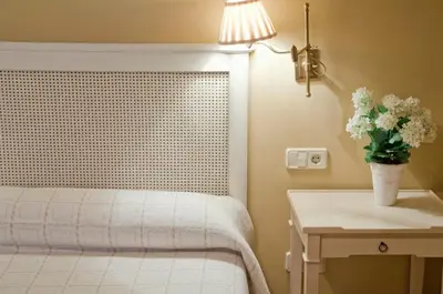 a bedroom with a bed and a table with a vase of flowers at A Casa da Torre Branca in Santiago de Compostela