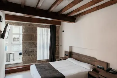 a bedroom with a bed and a large window at Via Aetcal Hotel & Wellness in Santiago de Compostela