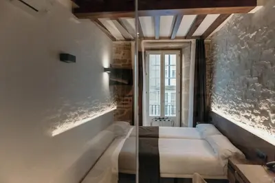 a bedroom with two beds and a window at Via Aetcal Hotel & Wellness in Santiago de Compostela