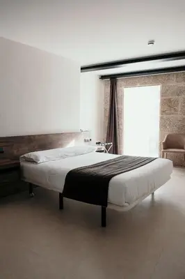 a large bed in a room with a window at Via Aetcal Hotel & Wellness in Santiago de Compostela
