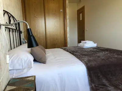 a bedroom with a bed with a black lamp on it at Pension 23-Vinte e Tres in O Pedrouzo