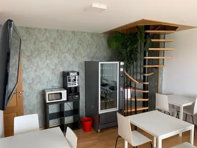 a dining room with a table and a spiral staircase at Pension 23-Vinte e Tres in O Pedrouzo