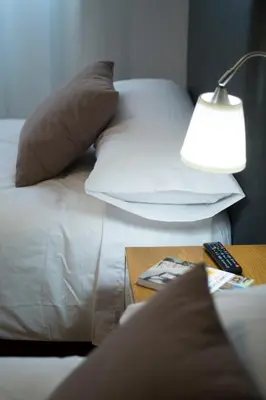 a bed with pillows and a table with a lamp at Pension 23-Vinte e Tres in O Pedrouzo