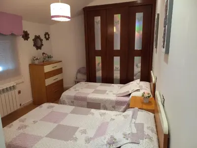 a bedroom with two beds and a dresser and a mirror at O Lar de Sara in Pontevedra