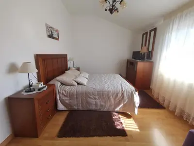 a bedroom with a bed and a dresser and a window at O Lar de Sara in Pontevedra