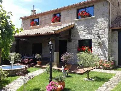 a stone house with flower boxes on the windows at O Lar de Sara in Pontevedra