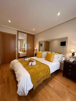 a large hotel room with a large bed with yellow pillows at Clarens Guesthouse in Cangas del Narcea