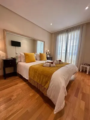 a bedroom with a large bed and a window at Clarens Guesthouse in Cangas del Narcea