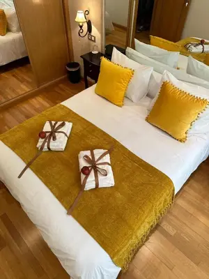 a bedroom with a large bed with a orange blanket at Clarens Guesthouse in Cangas del Narcea