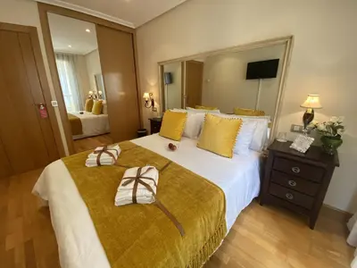 a large bed with two towels and bows on it at Clarens Guesthouse in Cangas del Narcea