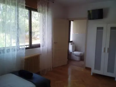 a bedroom with a bed and a window and a toilet at Casa Ribeira Sacra Portomarin in Portomarin