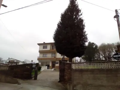 a house with a tree in front of a fence at Casa Ribeira Sacra Portomarin in Portomarin
