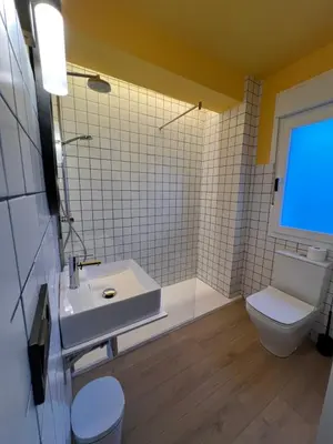 a bathroom with a white sink and a toilet at Albergue O Burgo in O Pedrouzo